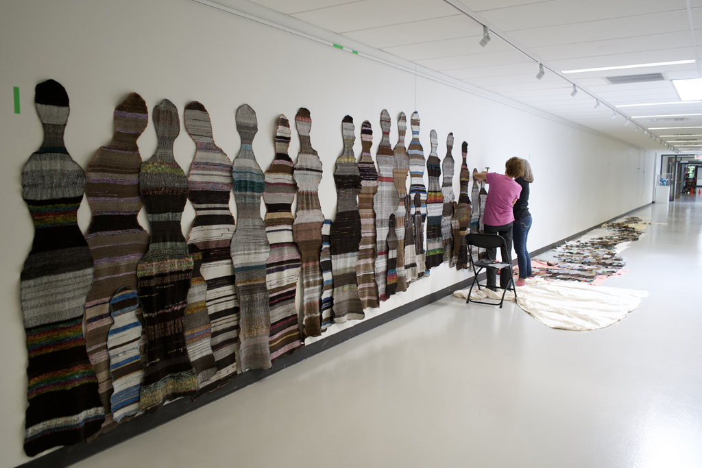 Festival Installer: Margaret and Artist: Carolyn Carson and installing The Ovine Conspiracy installation, World of Threads Festival 2023-24.