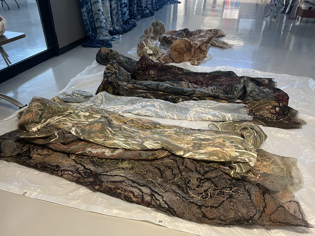 Laying out artwork ready to install, World of Threads Festival 2023-24.