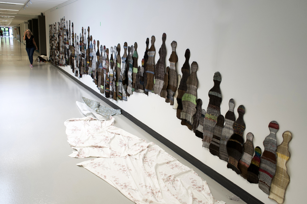 Artist: Carolyn Carson installing The Ovine Conspiracy installation, World of Threads Festival 2023-24.