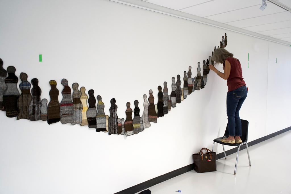 Artist: Carolyn Carson installing The Ovine Conspiracy installation, World of Threads Festival 2023-24.