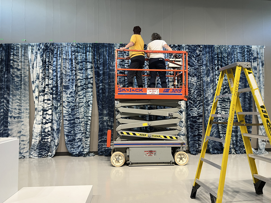 Festival Installers: Freda and Heidi, installing Pacific Ocean, World of Threads Festival 2023-24.