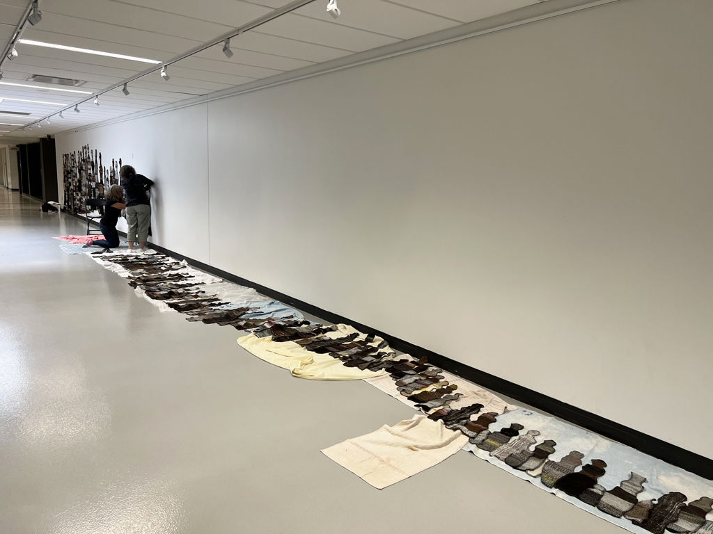 Laying out The Ovine Conspiracy installation, World of Threads Festival 2023-24.