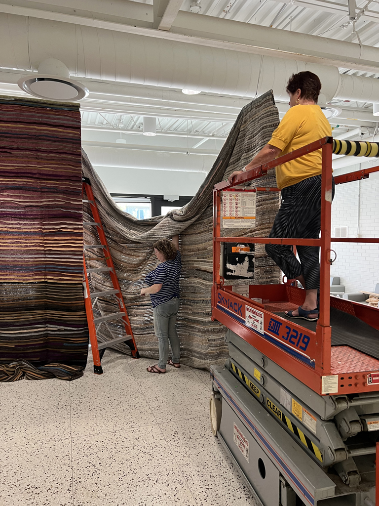 Festival installers: Melissa and Freda installing the Time installation, World of Threads Festival 2023-24.