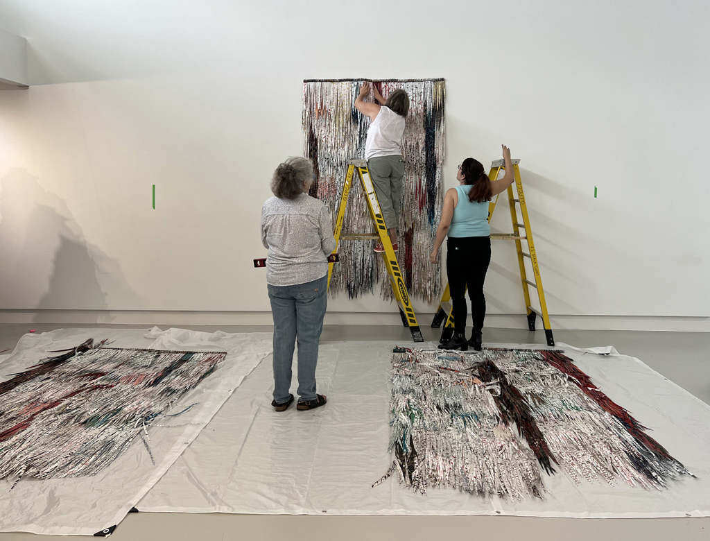 Festival installers Jean and Heidi, and assistant Sandra, hanging the installation of Deborah Kruger.