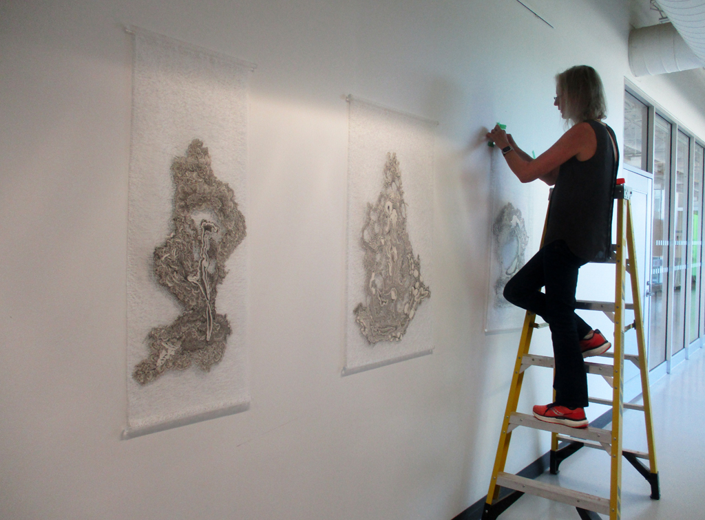Festival Installer: Caren installing artwork of Szilvia Revesz, Solo Shows, World of Threads Festival 2023-24.