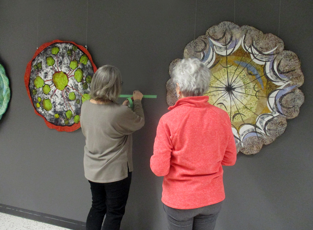 Festival Installer: Heidi and Artist: Lorraine Roy, installing her work, Solo Shows, World of Threads Festival 2023-24.