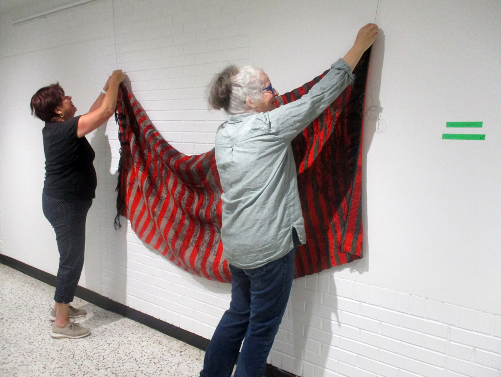 Festival Installers: Freda and Jean, installing work by C Pazia Mannella, Solo Show, World of Threads Festival 2023-24.