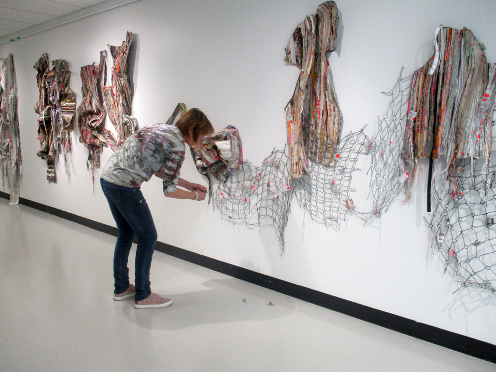 Artist: Margery Amdor, installing her artwork, Solo Show, World of Threads Festival 2023-24.