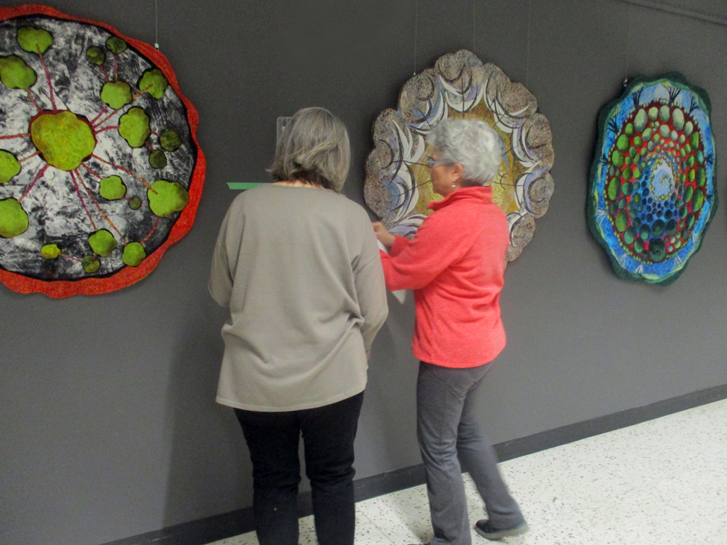 Festival Installer: Heidi and Artist: Lorraine Roy, installing her work, Solo Shows, World of Threads Festival 2023-24.