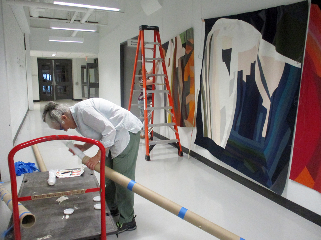 Festival Installers: Jean and Melissa, installing work by Roxanna Kantarjian, Solo Shows, World of Threads Festival 2023-24.