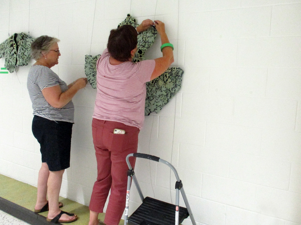 Festival Installers: Jeanne and Freda, installing artwork of George-Ann Bowers, Solo Shows, World of Threads Festival 2023-24.