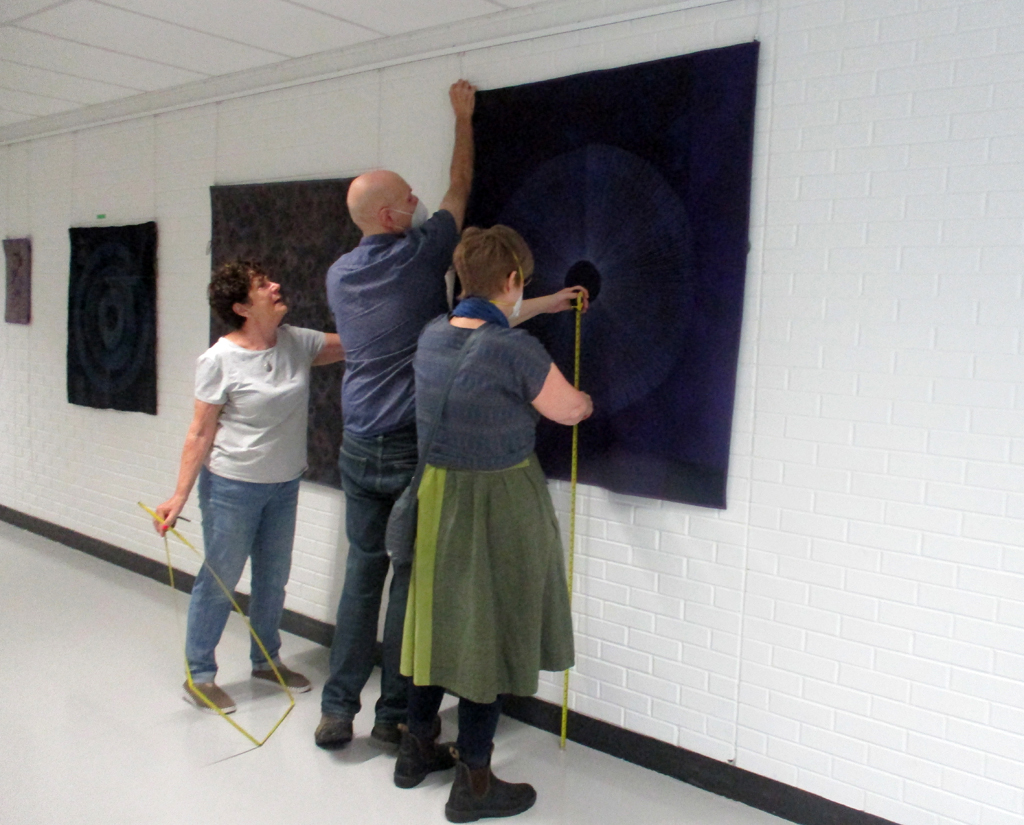 Festival Installer: Carol and Artist: Karen Thiessen, installing her work, Solo Shows, World of Threads Festival 2023-24.