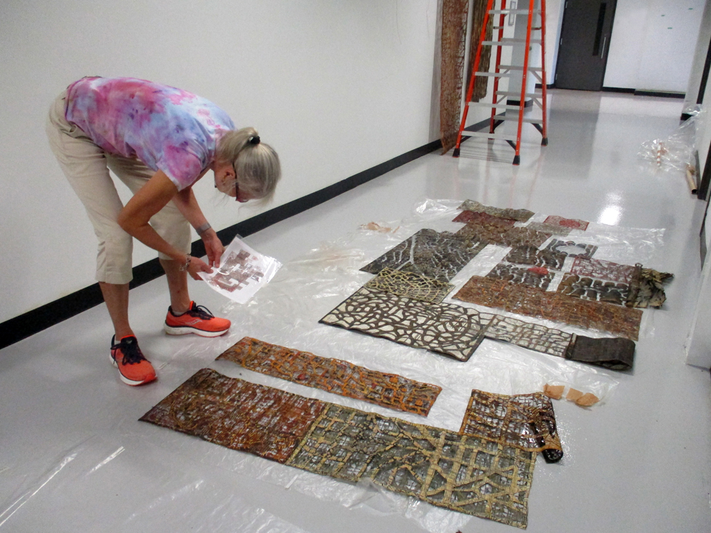 Festival installer: Caren installing artwork by Eszter Bornemisza, Solo Shows, World of Threads Festival 2023-24.