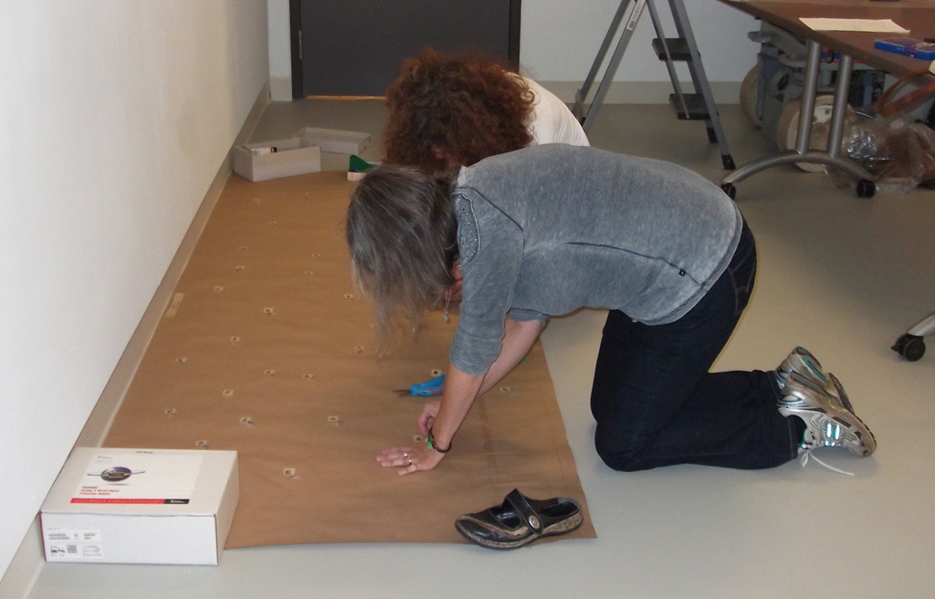 Festival installer: Ruth, and Artist: Dagmar Kovar installing artwork for The Red and the Black exhibition, World of Threads Festival 2014.