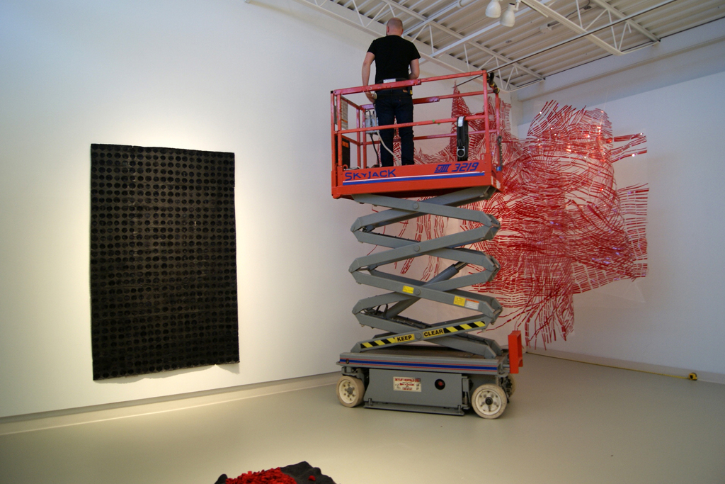 Installing artwork for The Red and the Black exhibition, World of Threads Festival 2014.