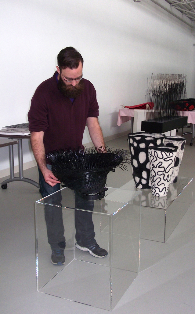 Festival Curator: Gareth installing artwork for The Red and the Black exhibition, World of Threads Festival 2014.