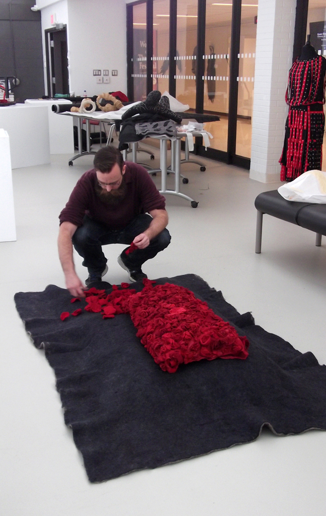 Festival Curator: Gareth installing artwork for The Red and the Black exhibition, World of Threads Festival 2014.