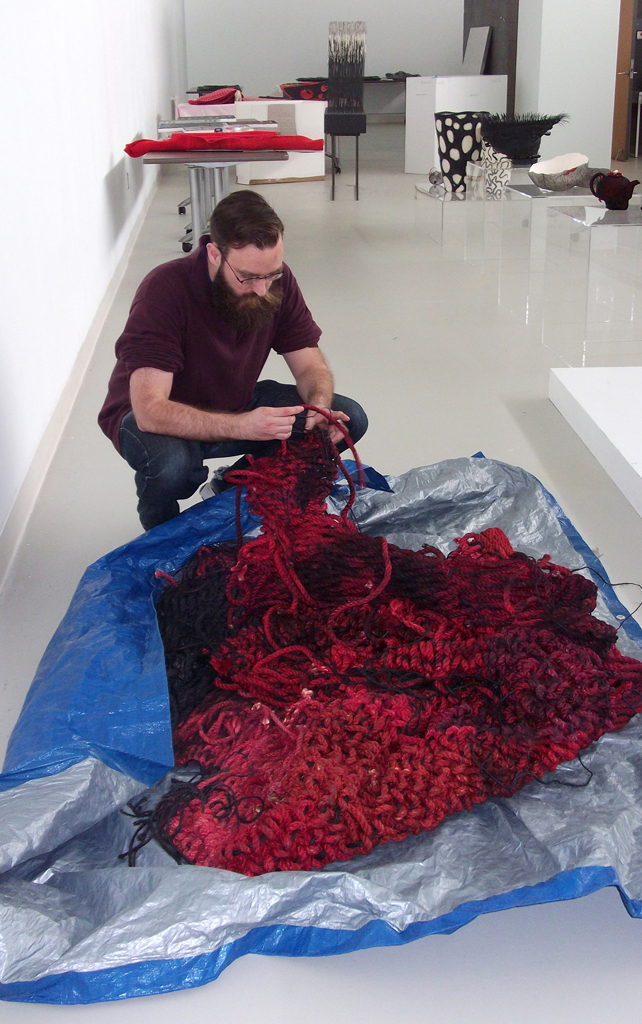 Festival Curator: Gareth installing artwork for The Red and the Black exhibition, World of Threads Festival 2014.