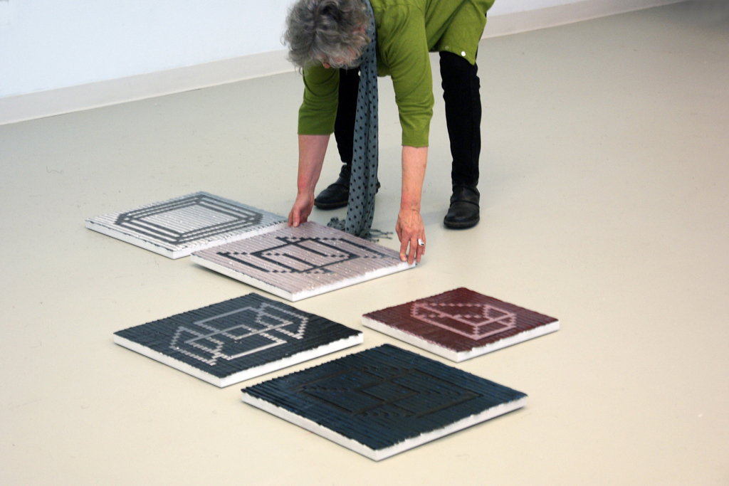 Festival installer: Carolyn, installing artwork for The Red and the Black exhibition, World of Threads Festival 2014.