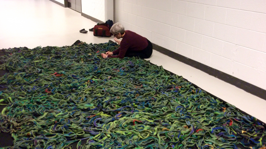 Artist: Mary Giehl installing her installation, World of Threads Festival 2014.