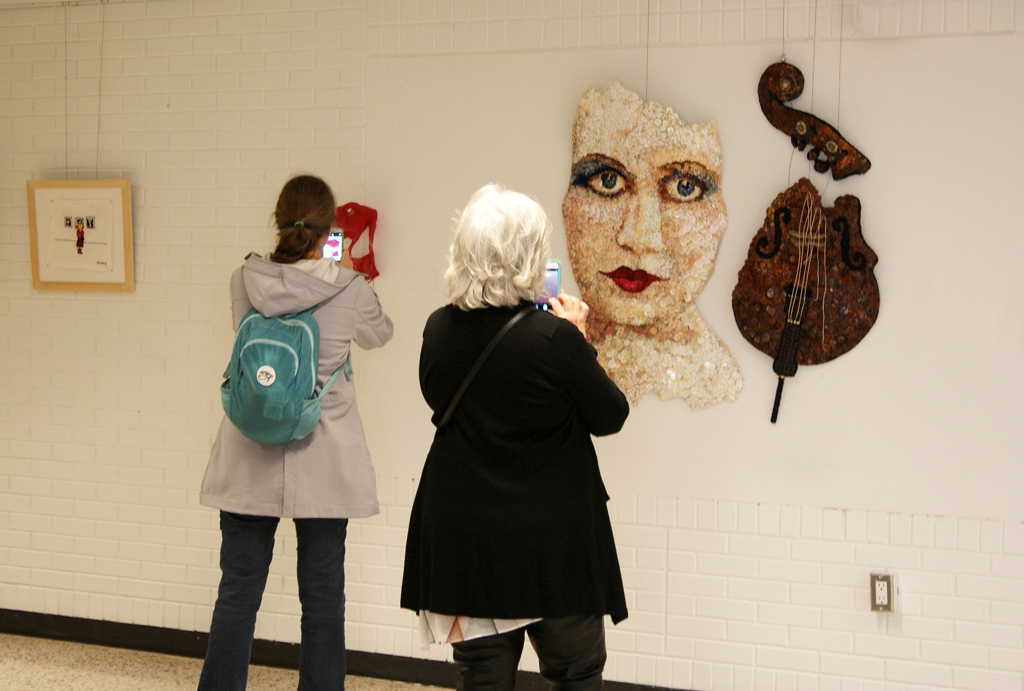 Visitors taking a close look at work by Marie Bergstedt, World of Threads Festival 2016.