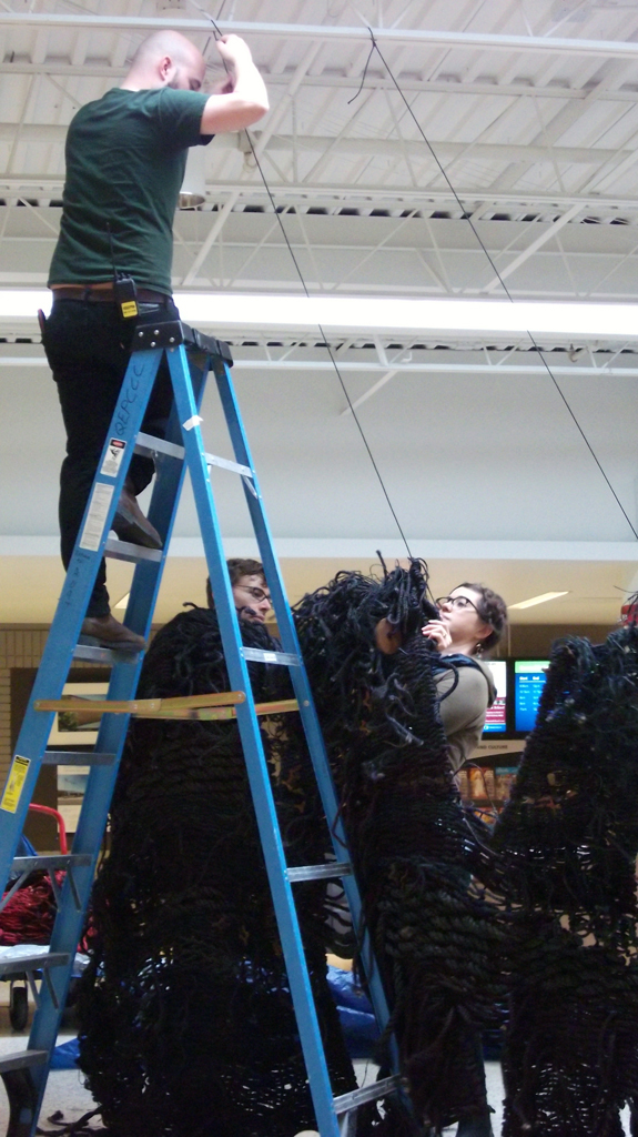 Artist: Mary Grisey helping to install her installation "Lethe", World of Threads Festival 2014.