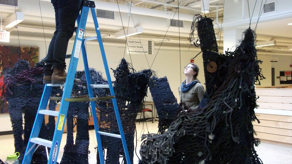 Artist: Mary Grisey helping to install her installation "Lethe", World of Threads Festival 2014.