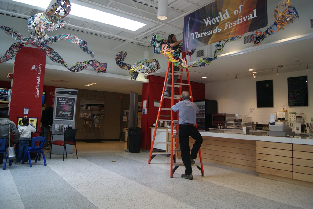 Artist: Olivia Tripp Morrow installing her art installation, World of Threads Festival 2016.